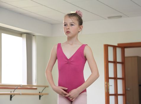 Young girl focusing at the teacher during her ballet lesson