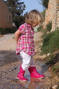 Girl playing in rain puddles