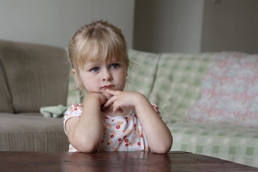 Horizontal photo of a 3 year old blond girl watching TV