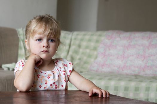 Horizontal photo of a 3 year old blond girl watching TV