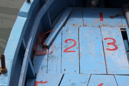Close up of a wooden boat with painted numbers on the decking