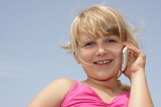 Horizontal photo of cute young girl talking on her mobile, Positive feeling. Space for text