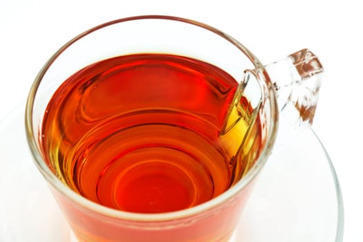 A cup of tea in a clear cup on a saucer