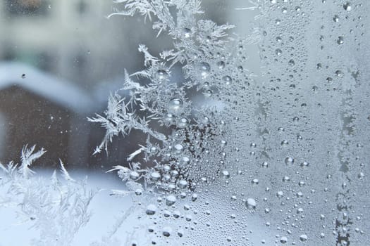 Ice crystals on a glass window of a home in Regina Canada, during the cold winter season