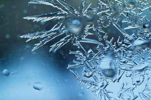 Ice crystals on a glass window of a home in Regina Canada, during the cold winter season