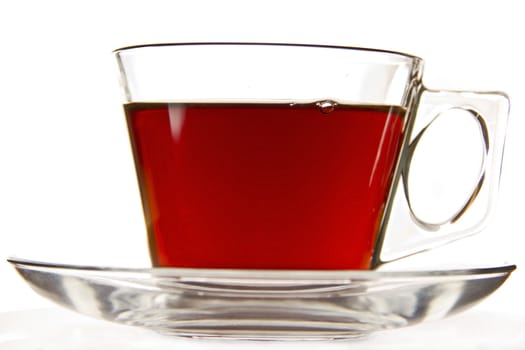 A cup of tea in a clear cup on a saucer