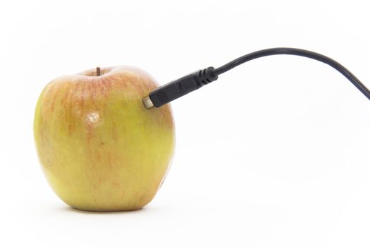 An actual apple plugged into a USB cable on a white background