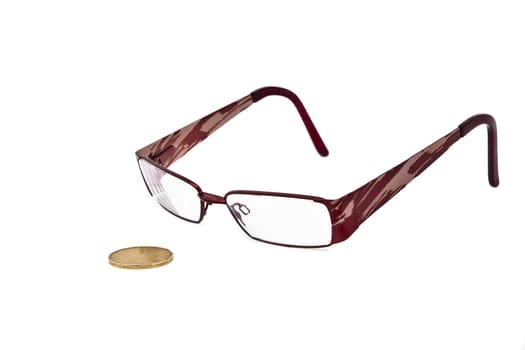 A  pair of eye glasses keeping a close eye on a canadian dollar bill. 