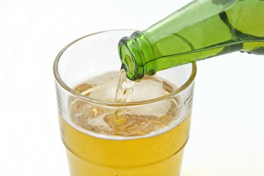 Pouring beer from a green beer bottle into a glass 