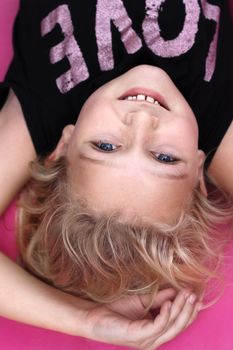 A 9 year old girl lying on the floor, upside down. 