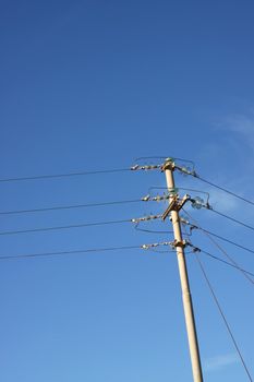 An old telephone pole against a clear blue sky. Space for free text