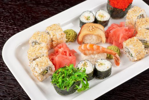 japanese sushi set and sushi with green seaweed closeup in the foreground