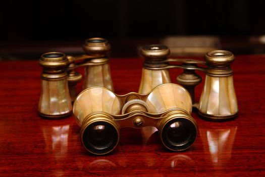 Three binoculars on a brown wood desk in old style