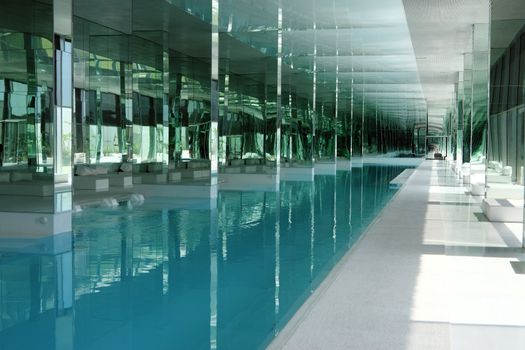 A luxury inside pool in a building with a lot of glasses