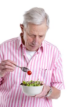 Senior man eating a healthy green salad out of a bowl