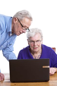 Elderly man and woman behind a laptop