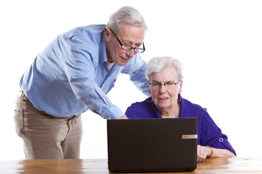 Senior man and woman behind the computer checking things out