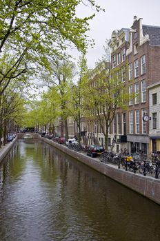 Canal in Amsterdam. Spring cityscape. Bicycles are on the waterfront.