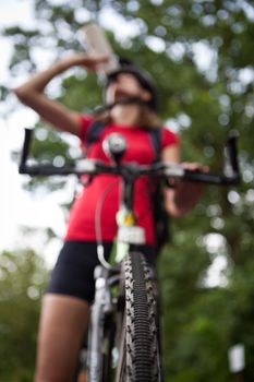 pretty young female biker outddors on her mountain bike (shallow DOF; selective focus)