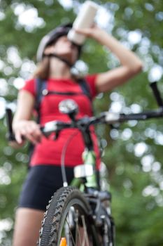 pretty young female biker outddors on her mountain bike (shallow DOF; selective focus)