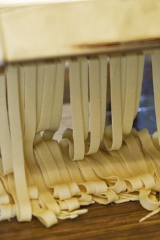 Freshly made pasta coming out of the pasta machine.