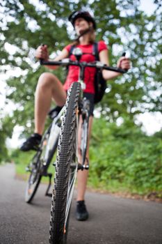 pretty young female biker outddors on her mountain bike (shallow DOF; selective focus)