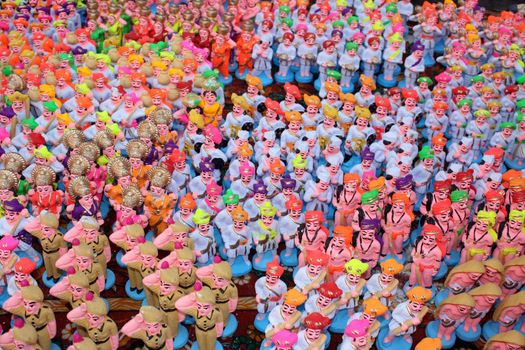 A background of colorful clay toys of various figures in traditional indian warriors or people.