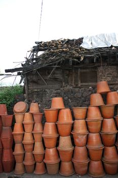 Clay pots stacked near the house of a poor Indian potter.
