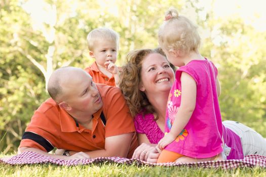 Adorable Happy Young Family with Cute Twins Enjoying a Day at the Park Together.