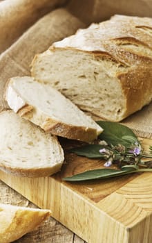 Freshly baked loaf of bread, just sliced with fresh herbs.