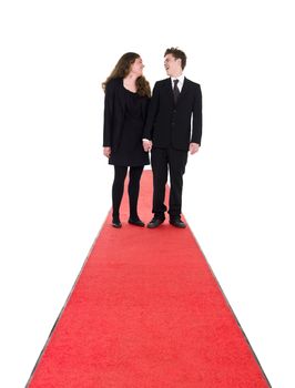 Couple standing on a red carpet isolated on white background