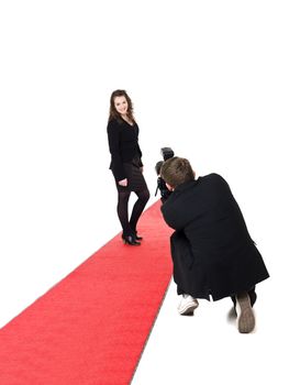 Photographer taking pictures on a woman posing on a red carpet