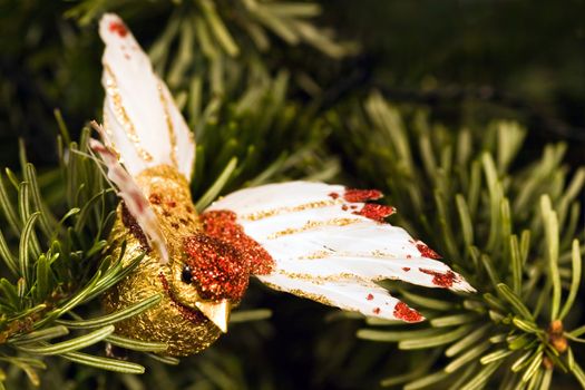 Handmade golden bird with birdfeathers as decoration in christmas tree
