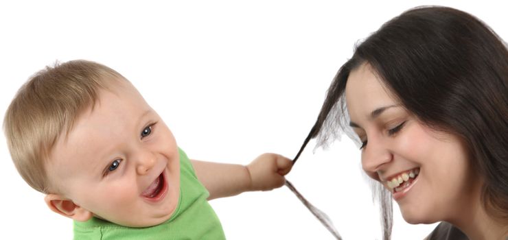 Baby boy pulling his mothers hair against white background