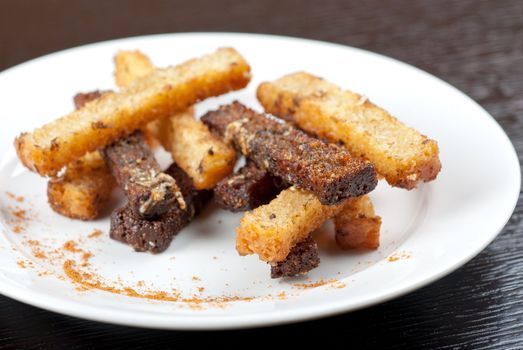 Rusk with garlic on a plate at wooden background