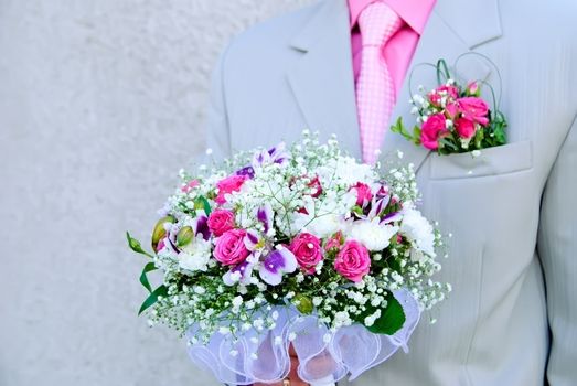 Bridal bouquet in the hand of the groom