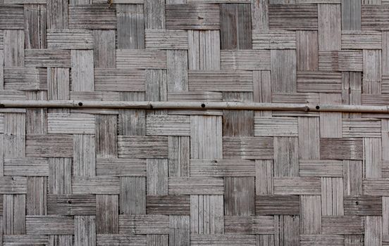 Bamboo wall of Laos house made from pieces of bamboo wood and arranged in Asian traditional pattern