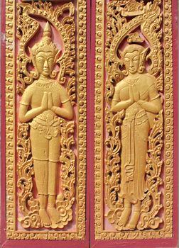 Decorated wooden beside door in Buddhist temple at Champasak Province, Laos