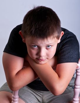 Young boy. Portrait in studio on a grey background.