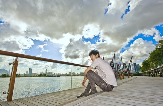 asian man sitting in park