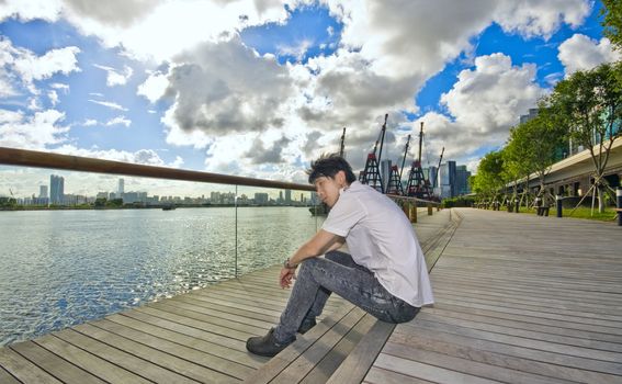 asian man sitting in park