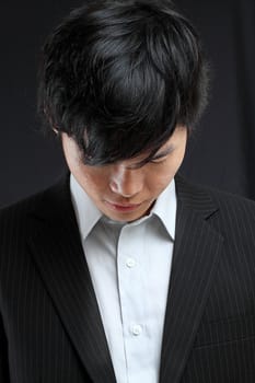 young asian man looking down