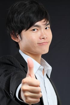 portrait of young man in suit and thumbs up