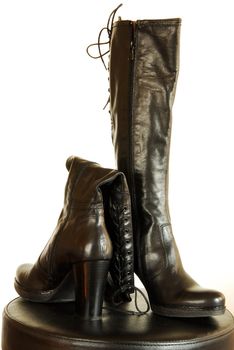 pair of female black leather fashionable boots over white background