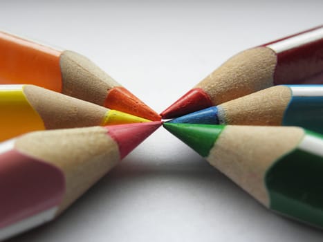 Colorful pencils arranged in an unusual way in the background paper.