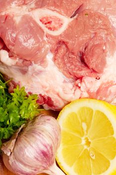 Raw meat, lemon, garlic and parsley. Closeup view
