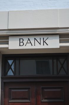 Old fashioned bank door sign in stone