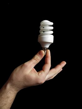 Men's hand holding a lamp. On a black background.