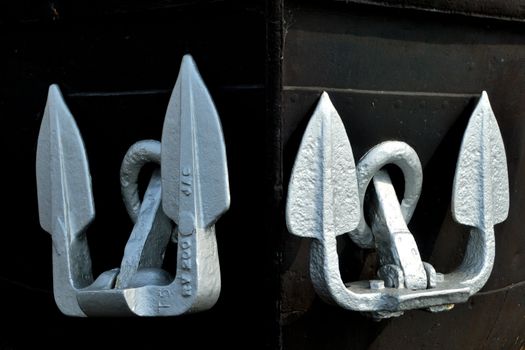 Pair of silver anchors on black background