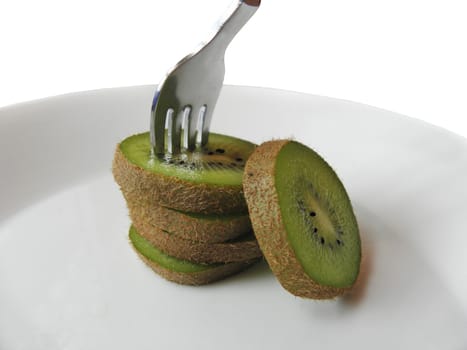 Kiwi sliced. Arranged on thin and fork is pinned on him.